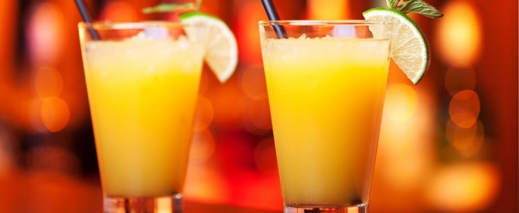 two glasses of a harvey wallbanger with a red orange background